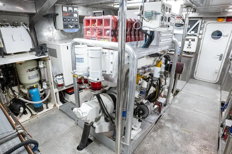 Slide: The Image of Engine room of a 1993 Queenship LRC yacht, featuring machinery and control panels. - 28