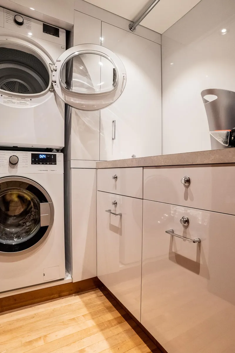 Slide: The Image of Laundry room with stacked washer and dryer, modern cabinetry, and wooden flooring on a 1993 Queenship LRC. - 31