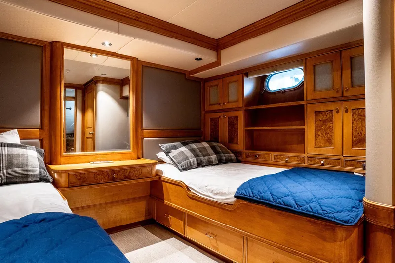 Slide: The Image of Luxurious 1993 Queenship LRC yacht cabin with twin beds, wood paneling, and nautical decor. - 33
