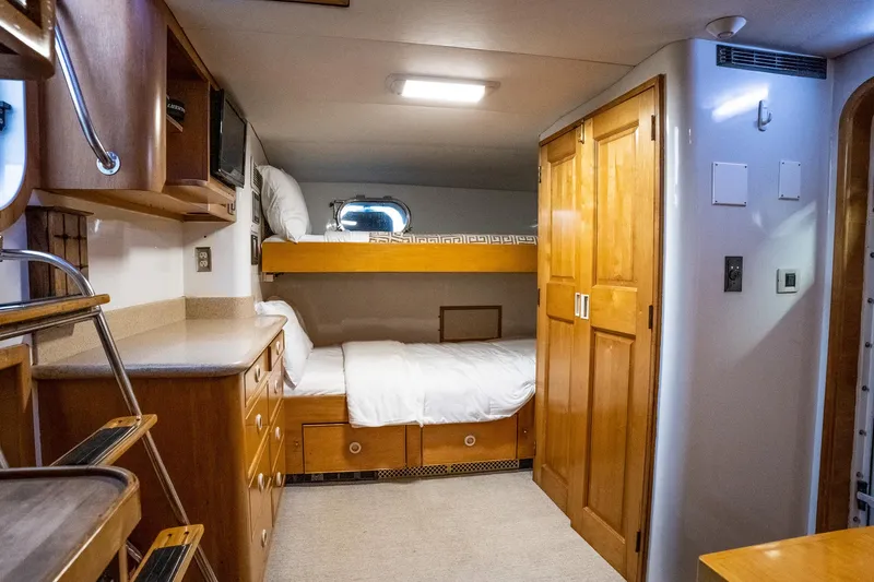 Slide: The Image of Cozy cabin interior of 1993 Queenship LRC yacht with bunk beds and wooden cabinetry. - 45