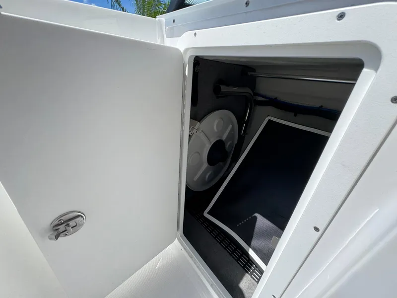 Slide: The Image of Open storage compartment on 2025 Monterey M-45 boat, showing interior details and latch. - 13