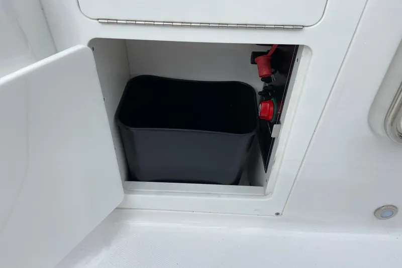 Slide: The Image of Storage compartment on a 2025 Monterey M-45 boat with a black container inside. - 16