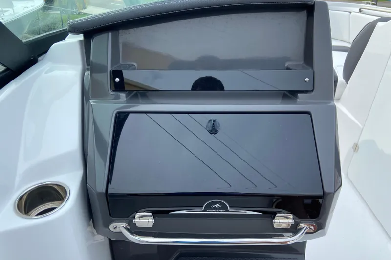 Slide: The Image of 2025 Monterey M-45 boat dashboard with sleek black panel and cup holder. - 22