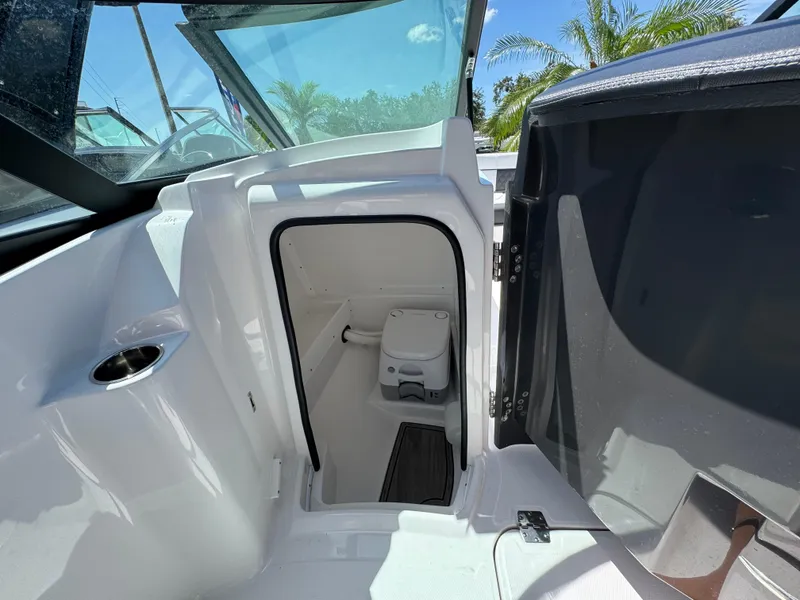 Slide: The Image of 2025 Monterey M-45 boat interior with compact bathroom and toilet, featuring sleek white design. - 24