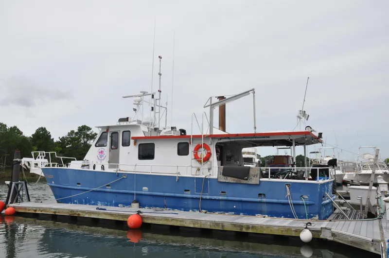 The Image of 1999 Rodriquez 50 Pilothouse boat docked, blue hull, red trim, marina setting. - 1