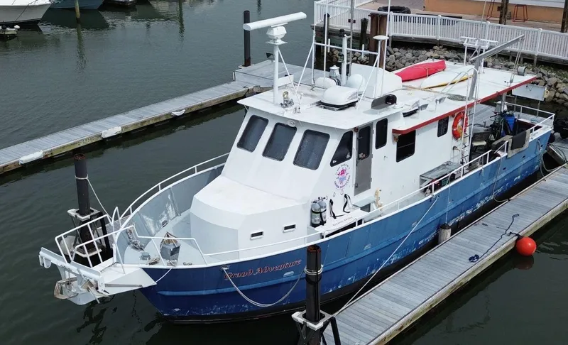 Slide: The Image of 1999 Rodriquez 50 Pilothouse boat docked at marina, featuring blue and white exterior. - 13