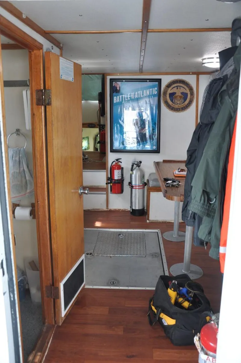Slide: The Image of Interior of 1999 Rodriquez 50 Pilothouse with wooden flooring, safety equipment, and nautical decor. - 18