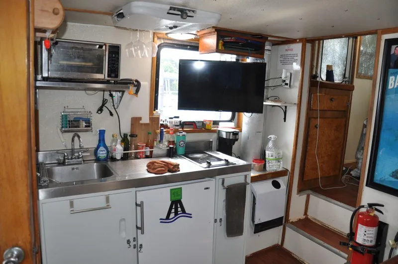 Slide: The Image of Compact kitchen area in a 1999 Rodriquez 50 Pilothouse boat with modern amenities. - 20
