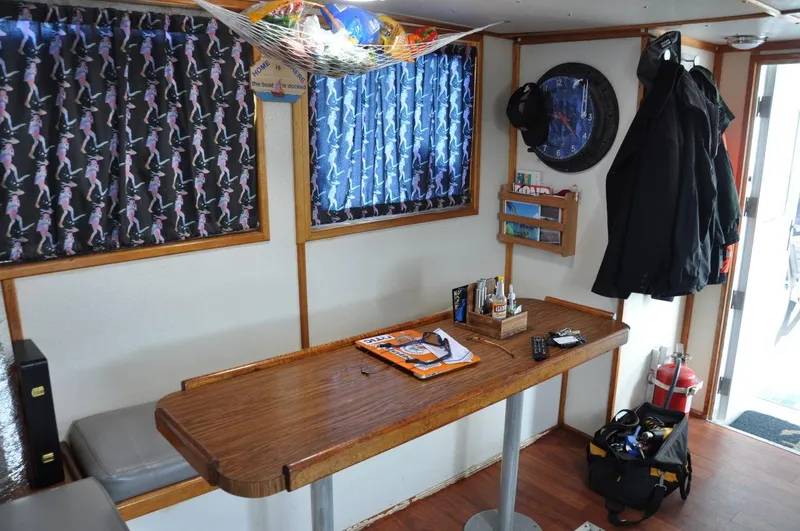 Slide: The Image of Interior of 1999 Rodriquez 50 Pilothouse with wooden table and decorative curtains. - 21
