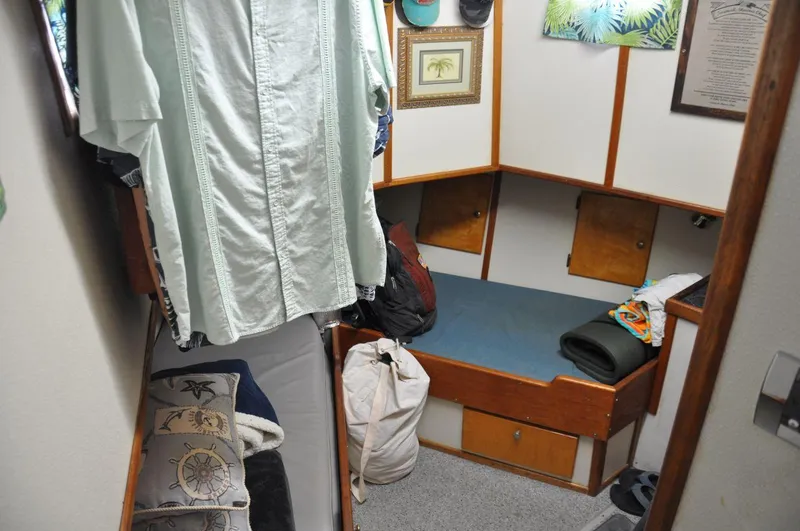 Slide: The Image of 1999 Rodriquez 50 Pilothouse cabin interior with bed, clothing, and decor. - 27