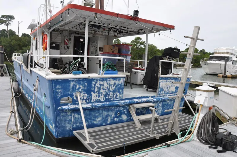 Slide: The Image of 1999 Rodriquez 50 Pilothouse boat docked, showing weathered blue exterior and deck equipment. - 3