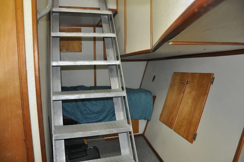 Slide: The Image of Interior of 1999 Rodriquez 50 Pilothouse with ladder, bed, and wooden cabinets. - 30