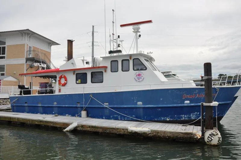 Slide: The Image of Rodriquez 50 Pilothouse 1999 boat docked at marina, blue and white exterior. - 5
