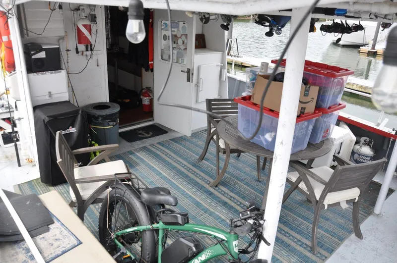 Slide: The Image of 1999 Rodriquez 50 Pilothouse boat interior with seating, storage bins, and bicycle. - 6
