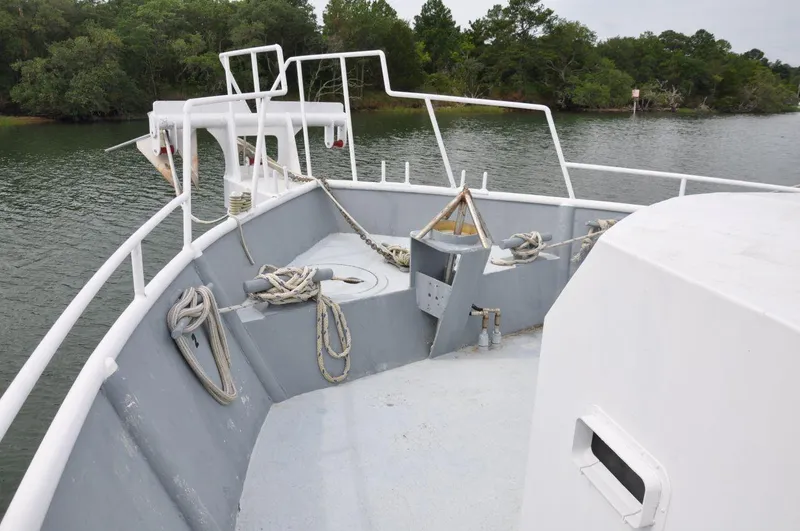 Slide: The Image of Rodriquez 50 Pilothouse 1999 boat deck with ropes and railing on calm water. - 8