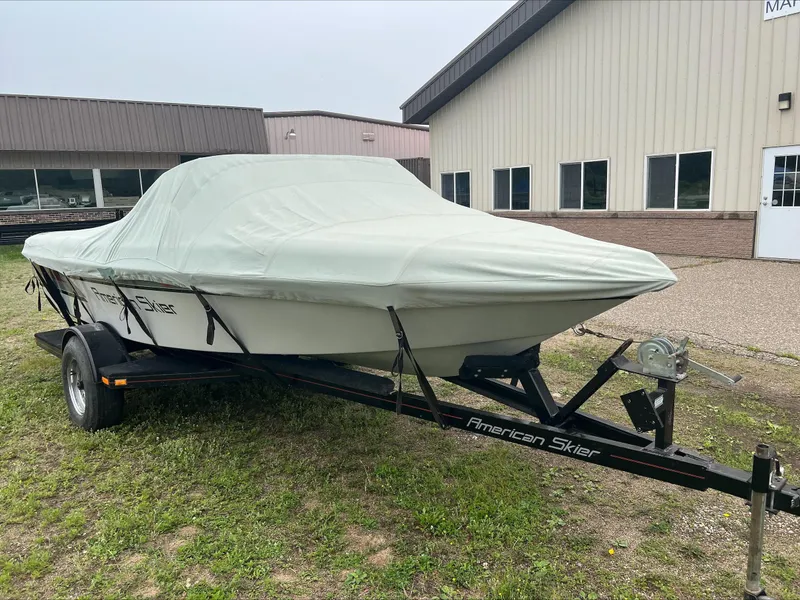 Slide: The Image of Covered 1990 American Skier Legend boat on trailer, parked outside a building. - 6