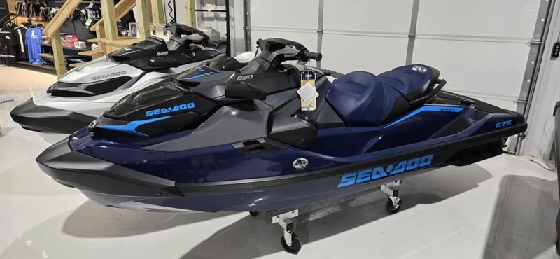 The Image of 2025 Sea-Doo GTX 230 jet ski in showroom, featuring sleek design and blue accents. - 0