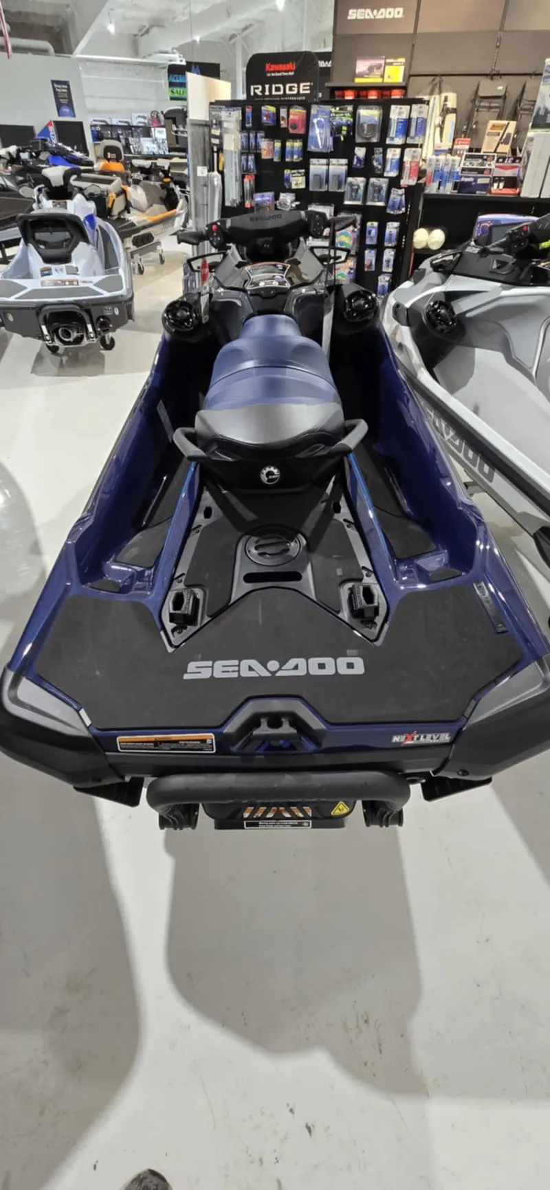 Slide: The Image of 2025 Sea-Doo GTX 230 jet ski in showroom, rear view. - 7