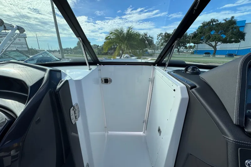 Slide: The Image of 2025 Monterey 255SS boat interior with open storage compartment, clear sky view. - 16