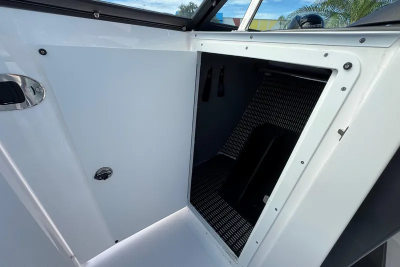 Slide: The Image of 2025 Monterey 255SS boat storage compartment with open door, showcasing interior details. - 17