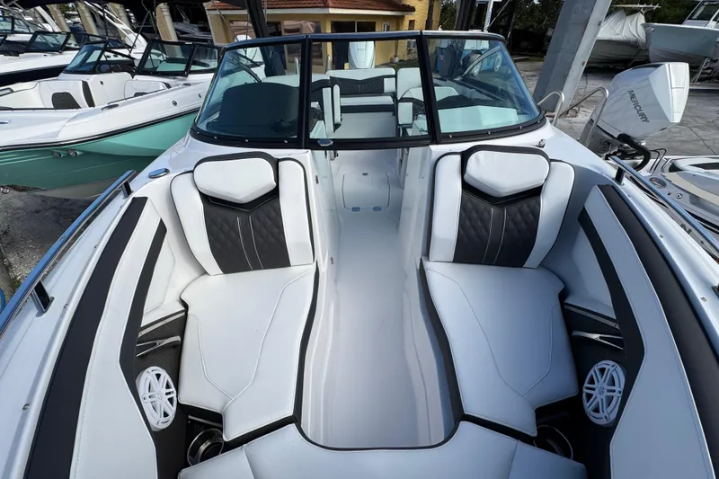 Slide: The Image of 2025 Monterey 255SS boat interior with sleek white and black seating, docked among other boats. - 19