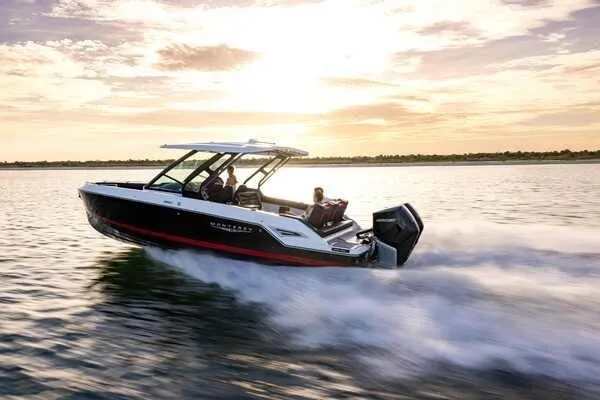 The Image of 2026 Monterey Elite 30 OB boat cruising on a serene lake at sunset. - 1
