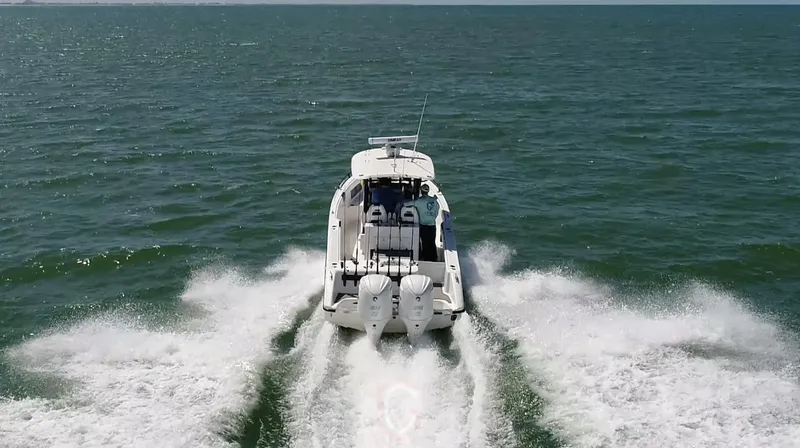 Slide: The Image of 2023 CG Boat Works 35 M-Series cruising on open water, rear view. - 44