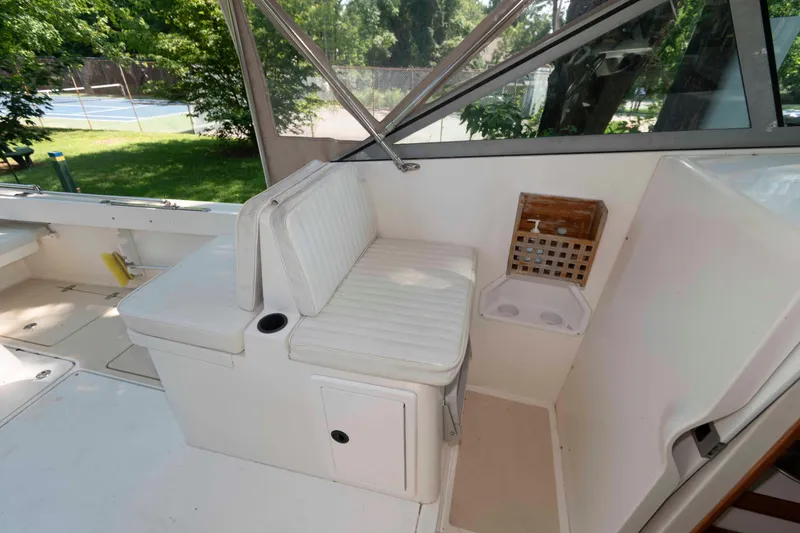 Slide: The Image of Interior of a 2005 Holby Pilot 24 boat with white seating and a small sink area. - 11