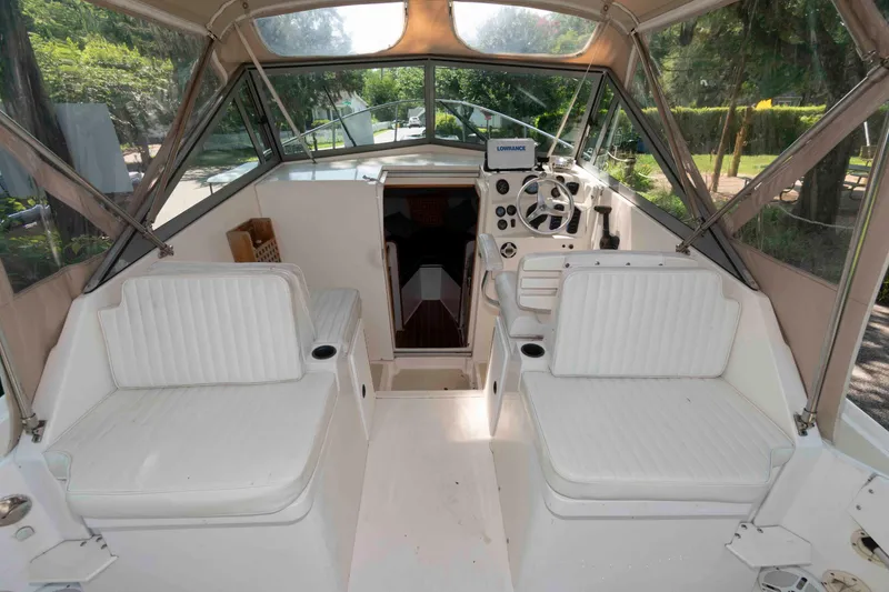 Slide: The Image of Interior of a 2005 Holby Pilot 24 boat with white seating and steering console. - 3
