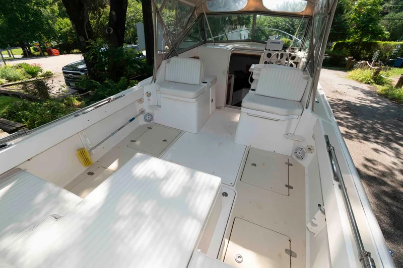 Slide: The Image of 2005 Holby Pilot 24 boat interior with seating and storage, surrounded by lush greenery. - 4