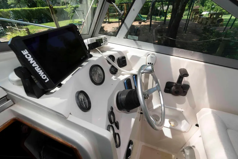 Slide: The Image of Interior of 2005 Holby Pilot 24 boat with steering wheel and navigation equipment. - 7