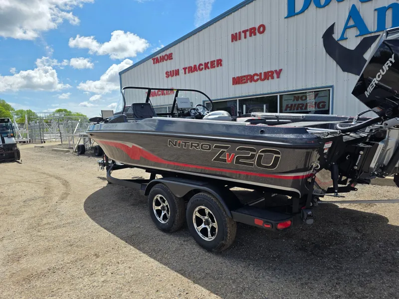Slide: The Image of 2025 Nitro ZV-20 SPORT boat on trailer, parked outside dealership under blue sky. - 2