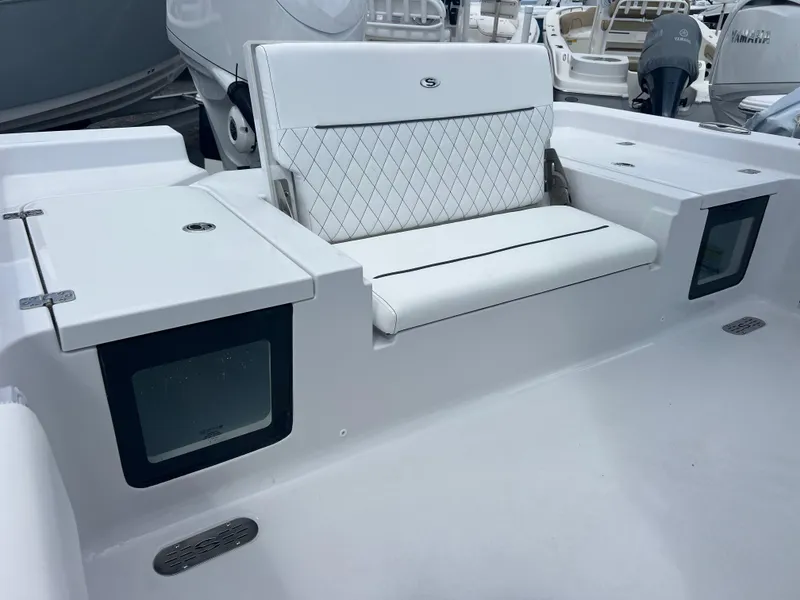 Slide: The Image of 2025 Sportsman Masters 247OE Bay Boat interior with white seating and storage compartments. - 19