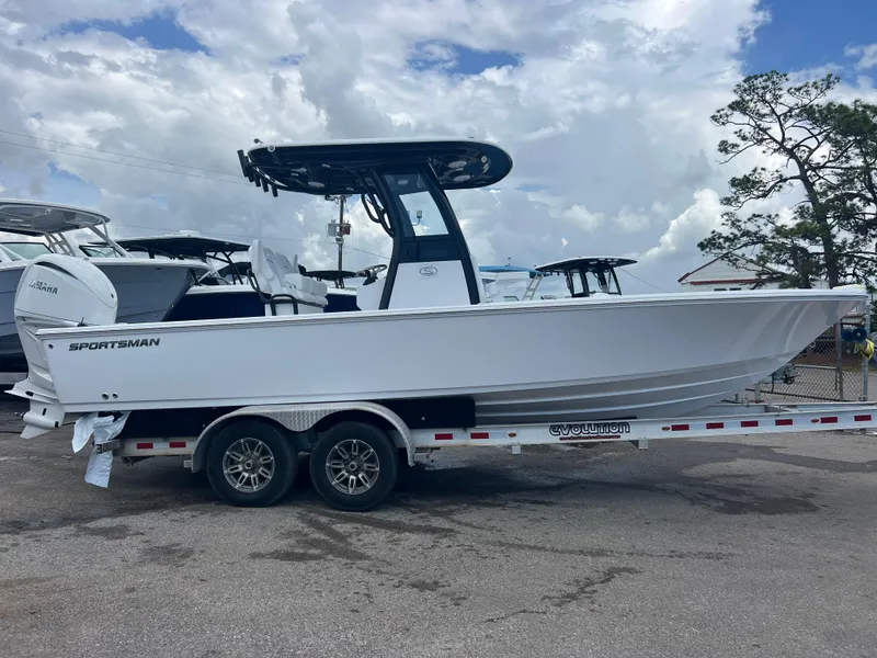 Slide: The Image of 2025 Sportsman Masters 247OE Bay Boat on trailer, parked outdoors under cloudy sky. - 2