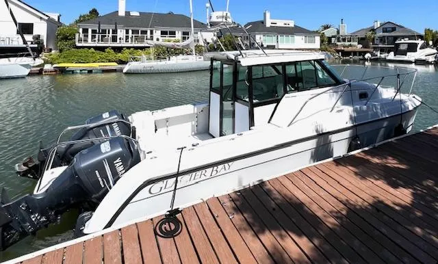 Slide: The Image of 2002 Glacier Bay 2690 Coastal Runner docked, featuring dual Yamaha outboard engines. - 0
