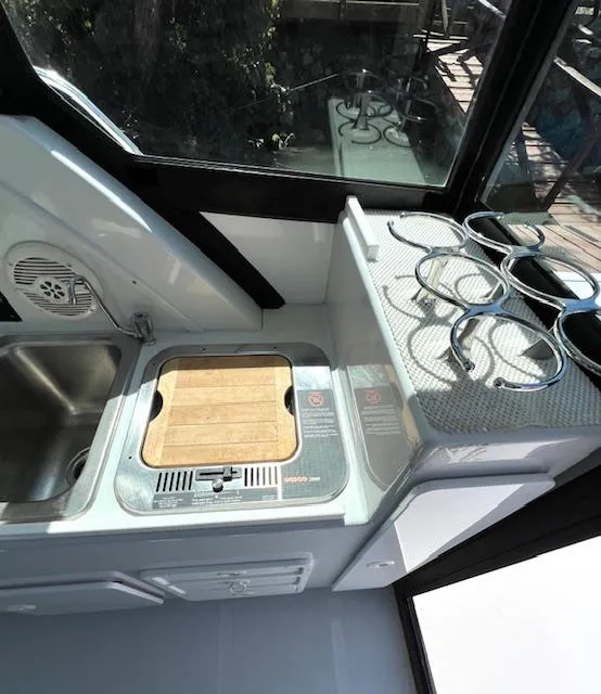 Slide: The Image of 2002 Glacier Bay 2690 Coastal Runner boat interior with sink and stove. - 11