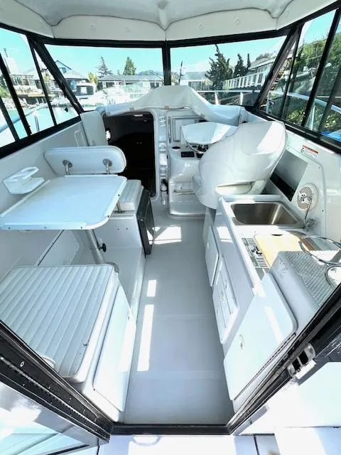 Slide: The Image of 2002 Glacier Bay 2690 Coastal Runner interior with seating, table, and kitchenette. - 14