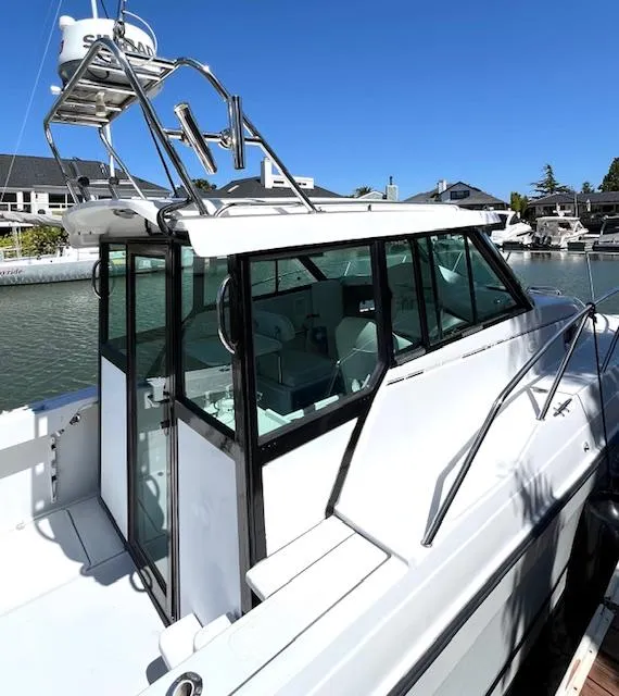 Slide: The Image of 2002 Glacier Bay 2690 Coastal Runner boat docked in marina under clear blue sky. - 2