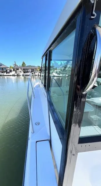 Slide: The Image of Side view of 2002 Glacier Bay 2690 Coastal Runner boat docked by calm waters. - 9