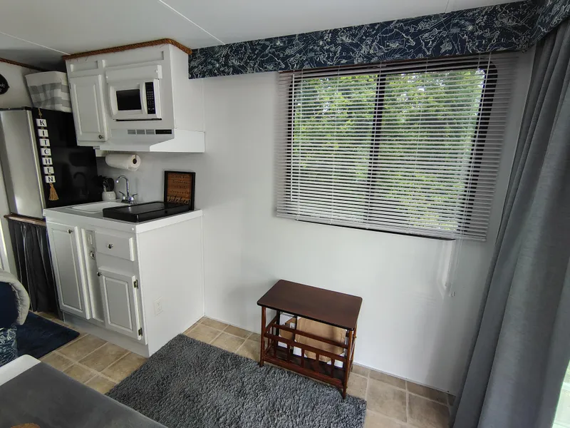 Slide: The Image of Interior of 2017 Catamaran Cruisers Lil Hobo 31 with kitchenette and window view. - 16