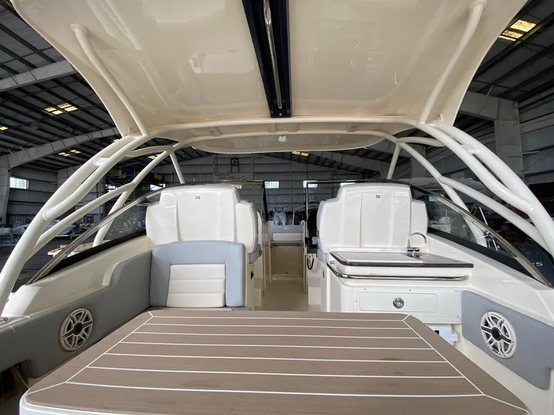 Slide: The Image of 2026 Scout 255 Dorado boat interior with seating and helm, in a warehouse setting. - 4