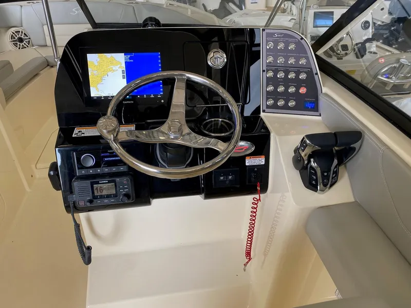 Slide: The Image of Helm of 2026 Scout 255 Dorado boat with steering wheel, controls, and navigation display. - 6