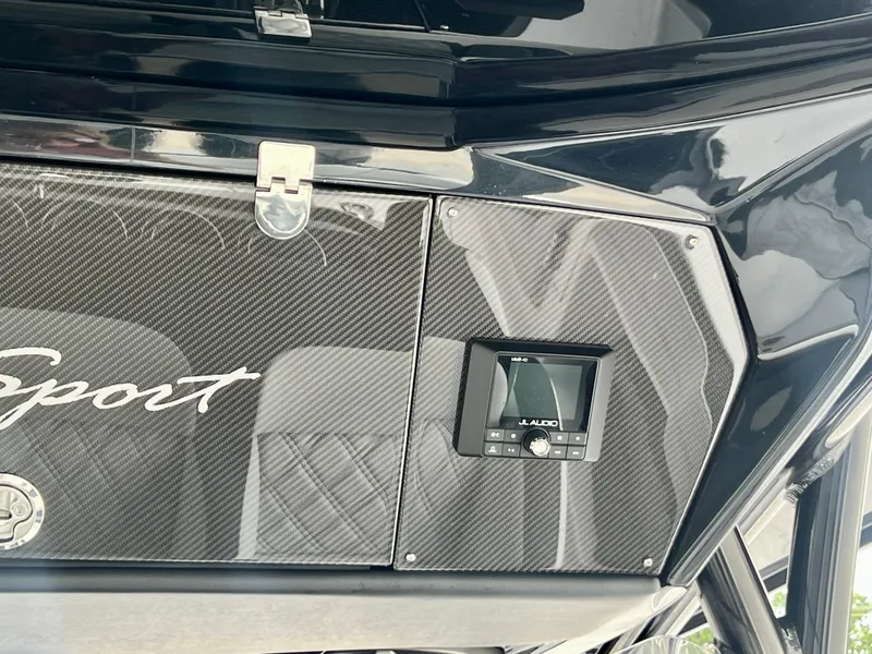 Slide: The Image of 2025 Nor-Tech 340 Sport Center Console dashboard with carbon fiber finish and audio controls. - 23