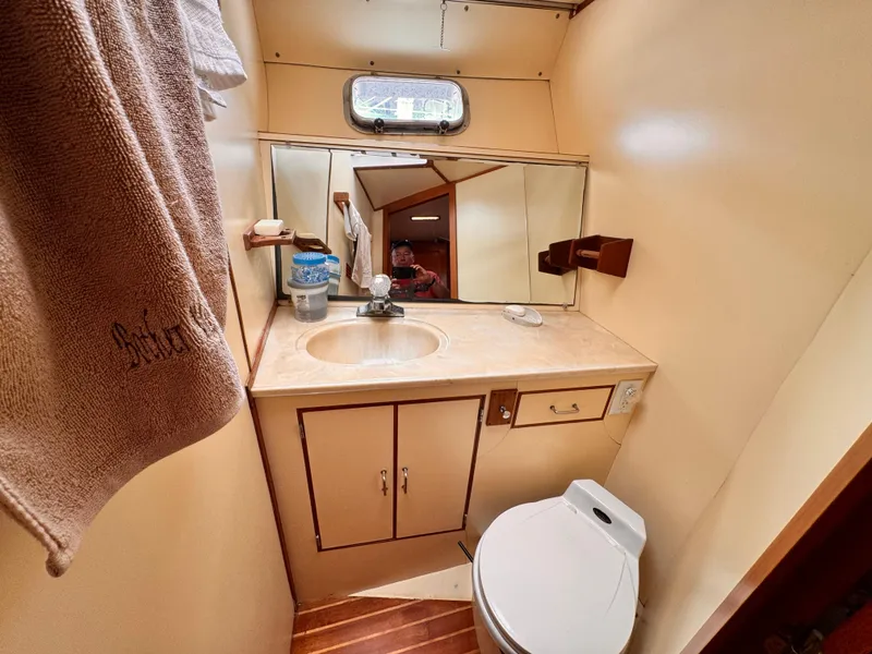 Slide: The Image of 1985 Symbol 51 Cockpit Motor Yacht bathroom with sink, mirror, and toilet. - 11
