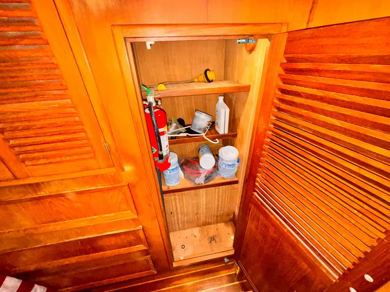 Slide: The Image of Storage cabinet on 1985 Symbol 51 Cockpit Motor Yacht with fire extinguisher and supplies. - 14