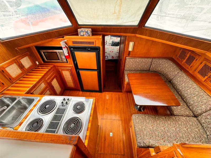 Slide: The Image of 1985 Symbol 51 Cockpit Motor Yacht interior with kitchen, dining area, and wood finish. - 7
