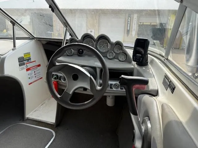 Slide: The Image of 2010 Bayliner 185S Bow Rider on trailer, parked outdoors, featuring blue and white design. - 9