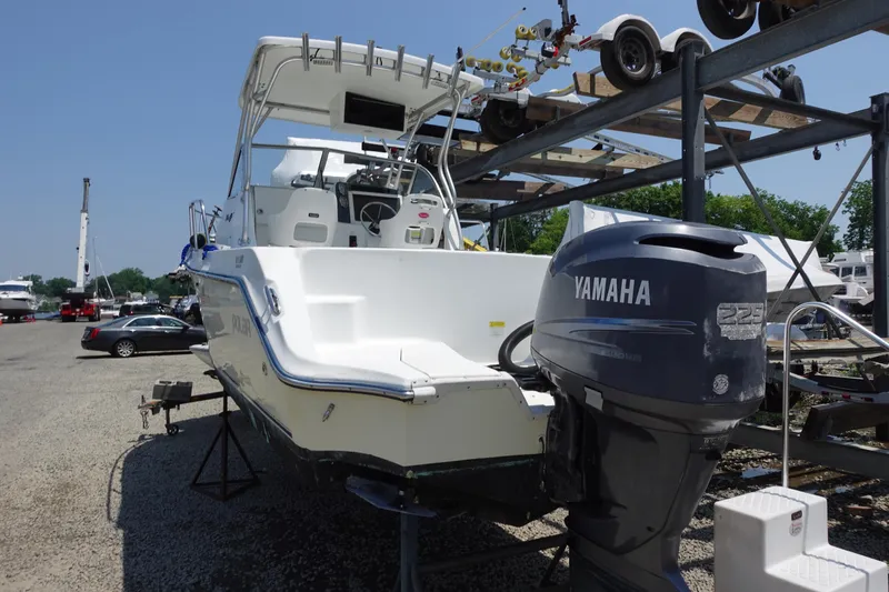 Slide: The Image of 2004 Polar 2300 Walkaround boat with Yamaha engine, parked on a trailer in a marina. - 2