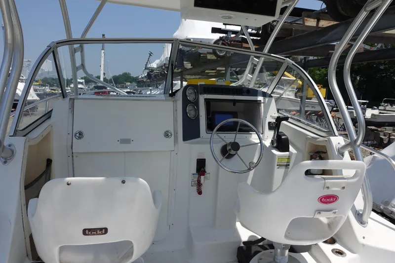 Slide: The Image of 2004 Polar 2300 Walkaround boat cockpit with steering wheel and seating. - 5