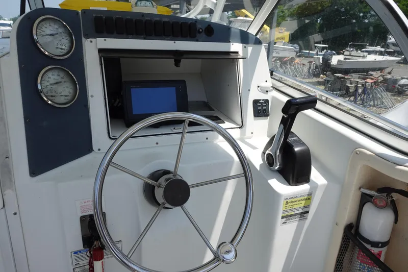 Slide: The Image of 2004 Polar 2300 Walkaround boat dashboard with steering wheel and controls. - 7